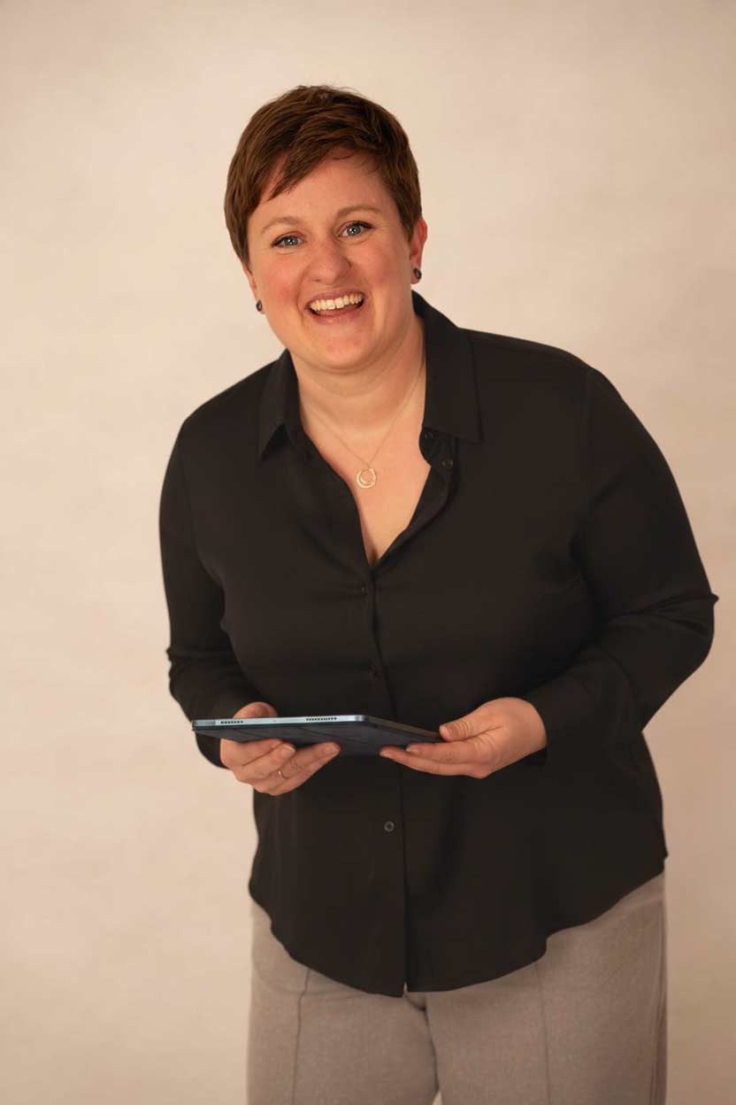 katrin-blome-longevity-coaching Bild von Katrin Blome, lachend, mit Tablet in den Händen